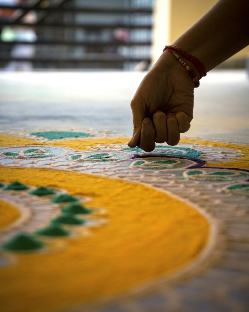 "Hands drawing traditional rangoli pattern - rhythmic regulation practice for overstimulated children"